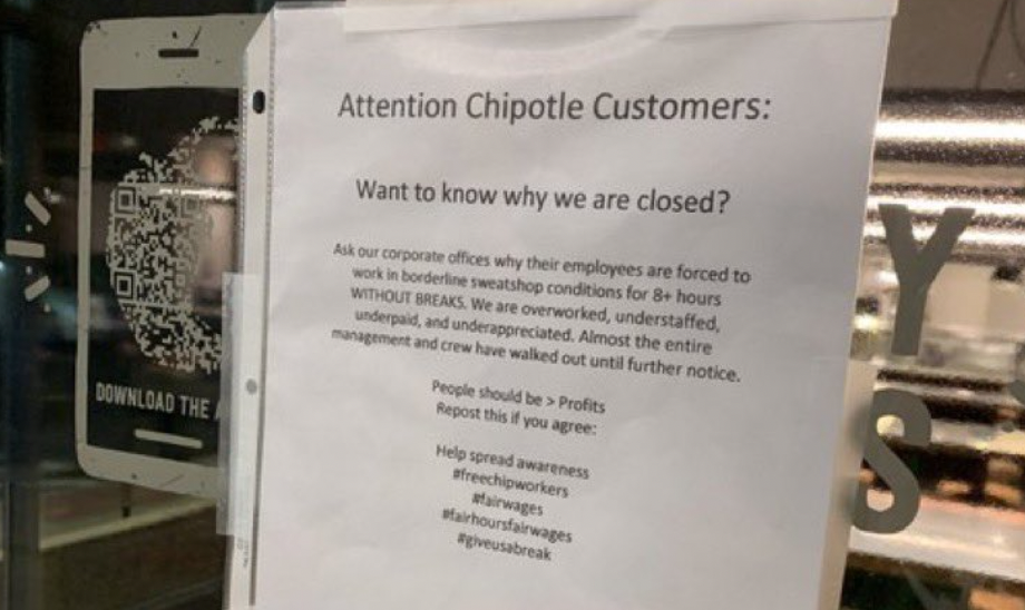 sign in the window of a Chipotle reading "Attention Chipotle customers: want to know why we are closed? Ask our corporate offices why their employees are forced to work in borderline sweatshop conditions for 8+ hours WITHOUT BREAKS. We are overworked, understaffed, underpaid and underappreciated. Almost the entire management and crew have walked out under further notice."