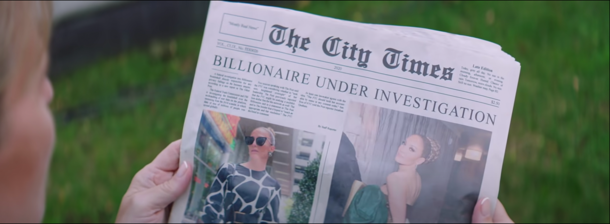 still from the music video: hands hold a newspaper with two images of J.Lo above the fold under the headline "BILLIONAIRE UNDER INVESTIGATION"