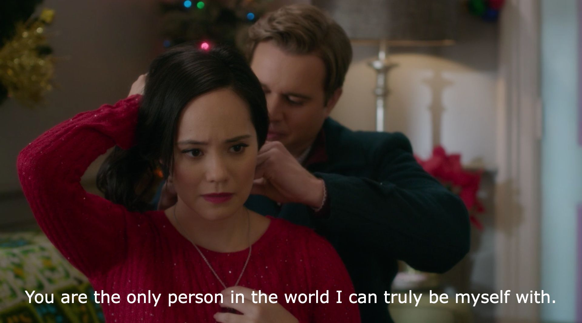 Screenshot of a man fastening a necklace for his girlfriend, who looks upset. The caption reads "You are the only person in the world I can truly be myself with."